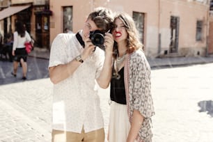 happy stylish couple taking selfie in a dirty mirror at old european city street, funny tender moment, space for text