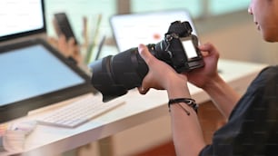 Photo d’un photographe travaillant avec un appareil photo professionnel dans un lieu de travail créatif.