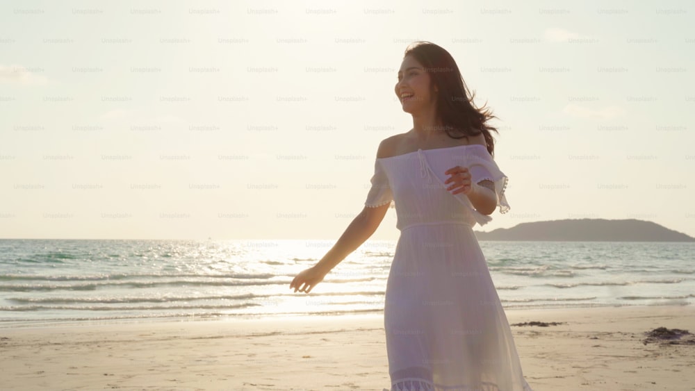 Young Asian woman walking on beach. Beautiful female happy relax ...