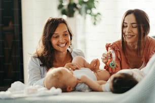 Two happy mothers spending time with their babies at home.