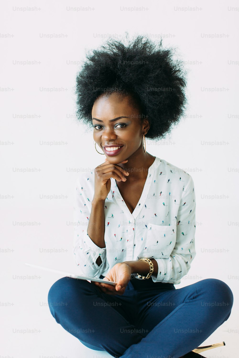 Young african american business woman using the tablet while sitting on the floor, isolated on white.