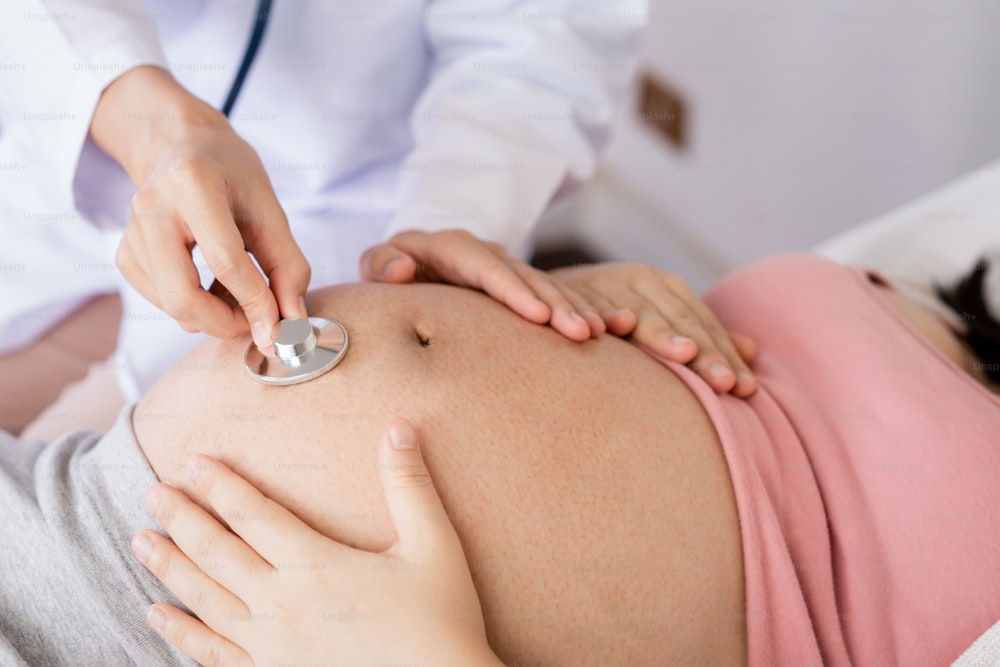 幸せな妊婦は、妊娠コンサルタントのために病院や診療所で婦人科医を訪ねます。医師は妊娠中のお腹を検査し、赤ちゃんと母親の健康診断を受けます。婦人科のコンセプト。