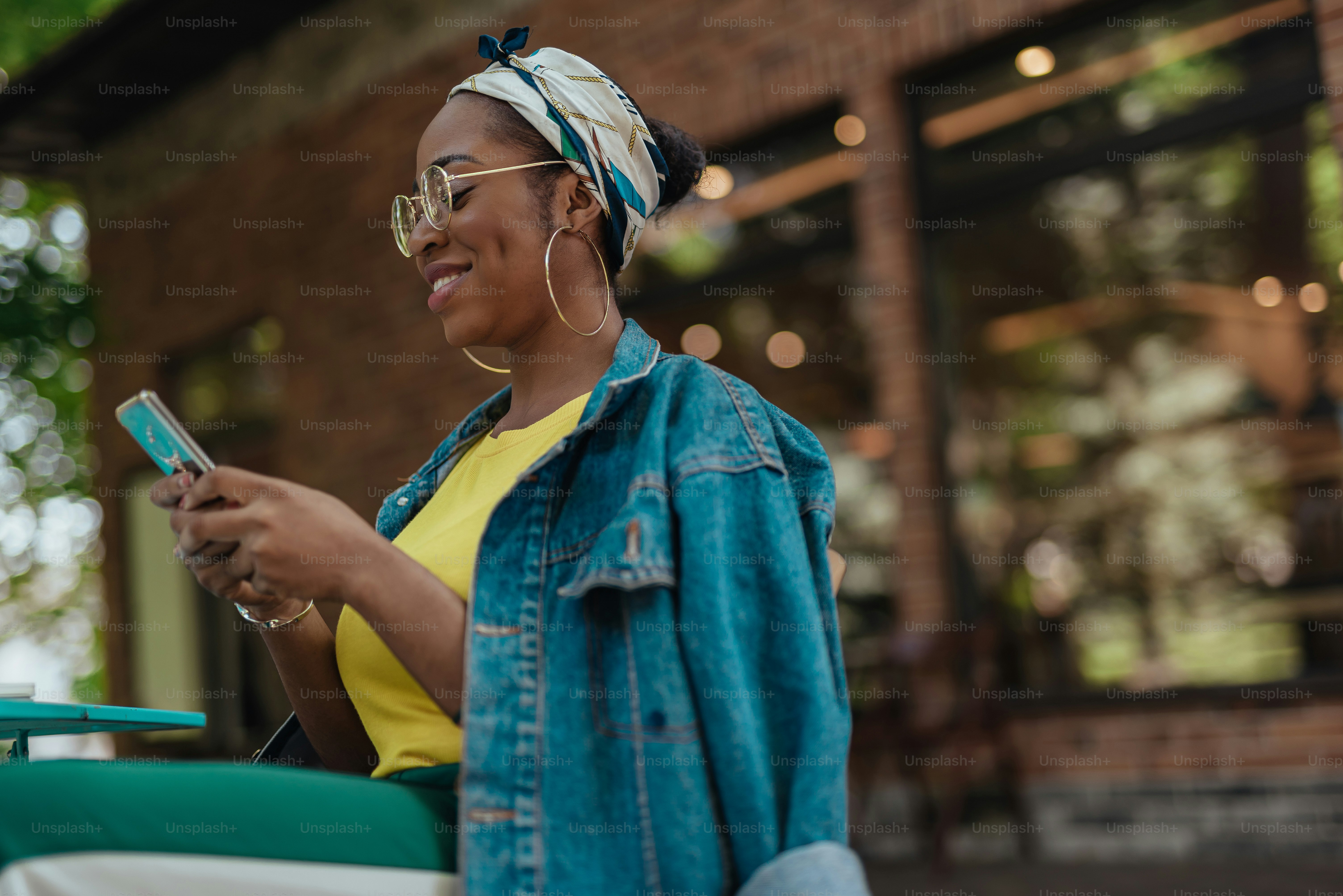 Glad young african american female using app on mobile phone photo ...