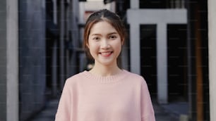 Cheerful beautiful young Asian woman feeling happy smiling to camera while traveling at Chinatown in Beijing, China. Lifestyle backpack tourist travel holiday concept. Portrait looking at camera.