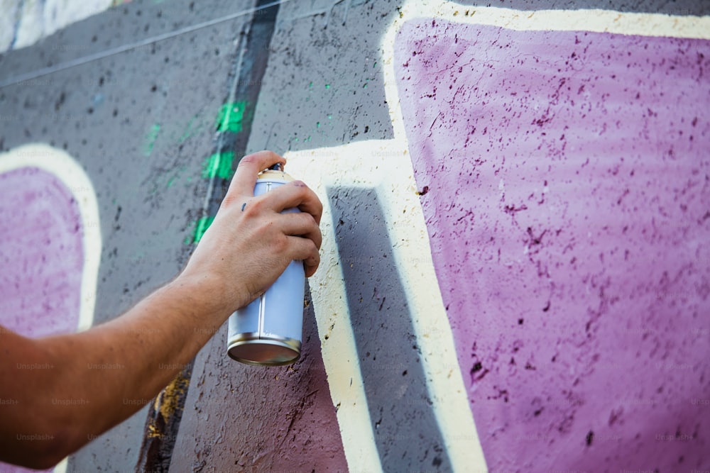 거리 예술가 그림 화려한 낙서 일반 벽 - 도시 남자가 공연하고 멀티 컬러 에어로졸 스프레이로 라이브 벽화를 준비하는 현대 미술 개념