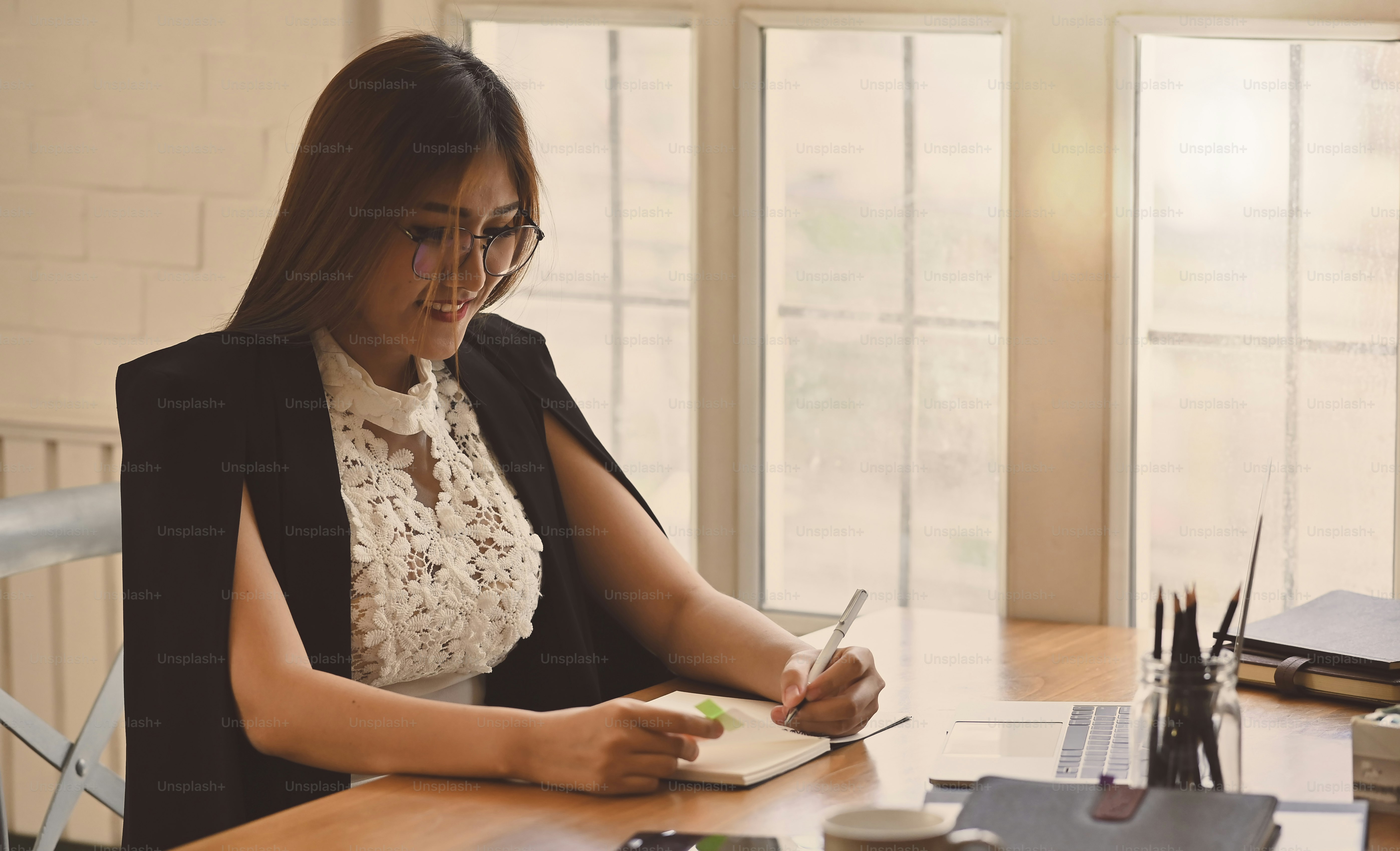 Asian woman working with pen on notebook paper with vintage tone.