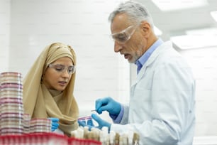 Being in al ears. Cheerful Muslim girl wearing hijab while working in laboratory