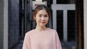 Cheerful beautiful young Asian woman feeling happy smiling to camera while traveling at Chinatown in Beijing, China. Lifestyle backpack tourist travel holiday concept. Portrait looking at camera.