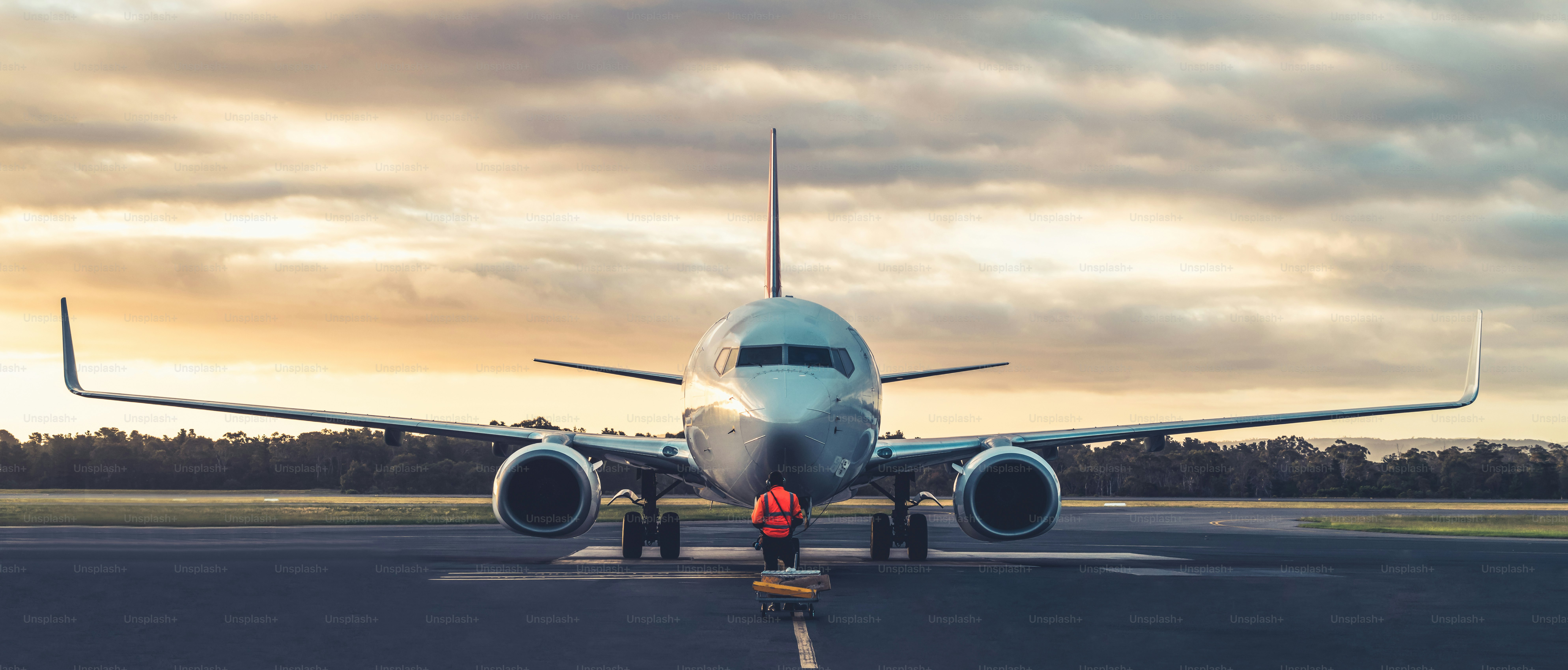 Sunset view of airplane on airport runway under dramatic sky in Hobart,Tasmania, Australia. Aviation technology and world travel concept.