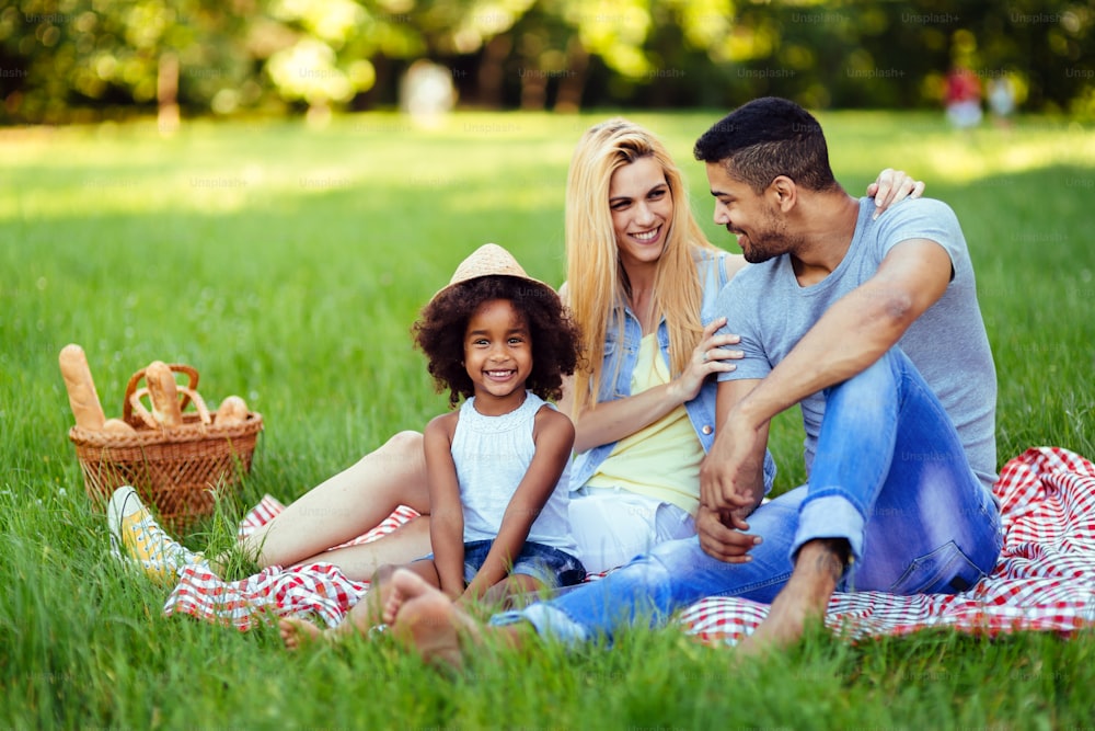 Picture of lovely couple with their daughter having picnic in nature