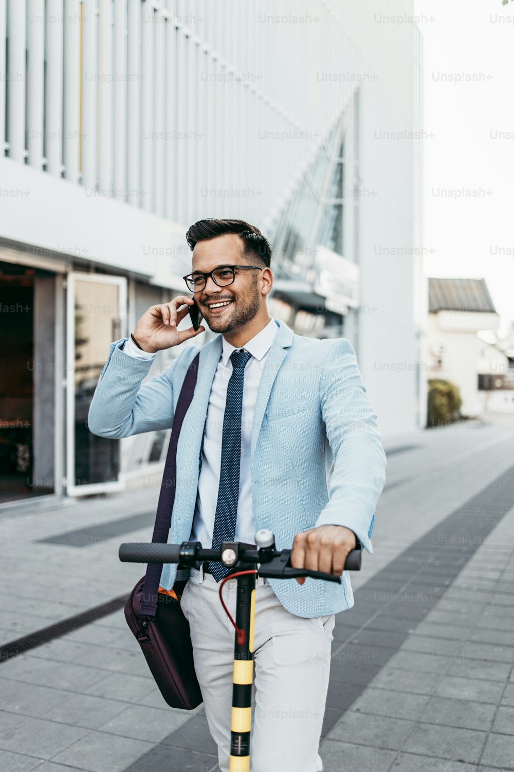Jovem homem moderno usando e dirigindo scooter elétrico na rua da cidade. Conceito de transporte moderno e ecológico.