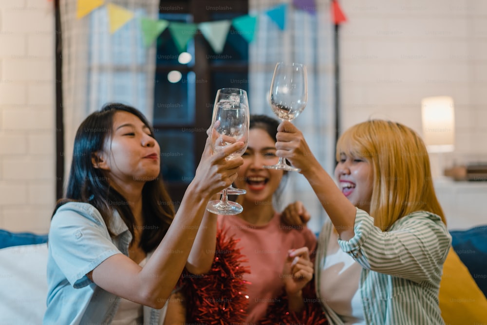 Grupo de mulheres asiáticas festa em casa, coquetel de bebida feminina conversando tendo engraçado juntos no sofá na sala de estar à noite. Adolescente jovem amigo jogar jogo, amizade, celebrar o conceito de férias.