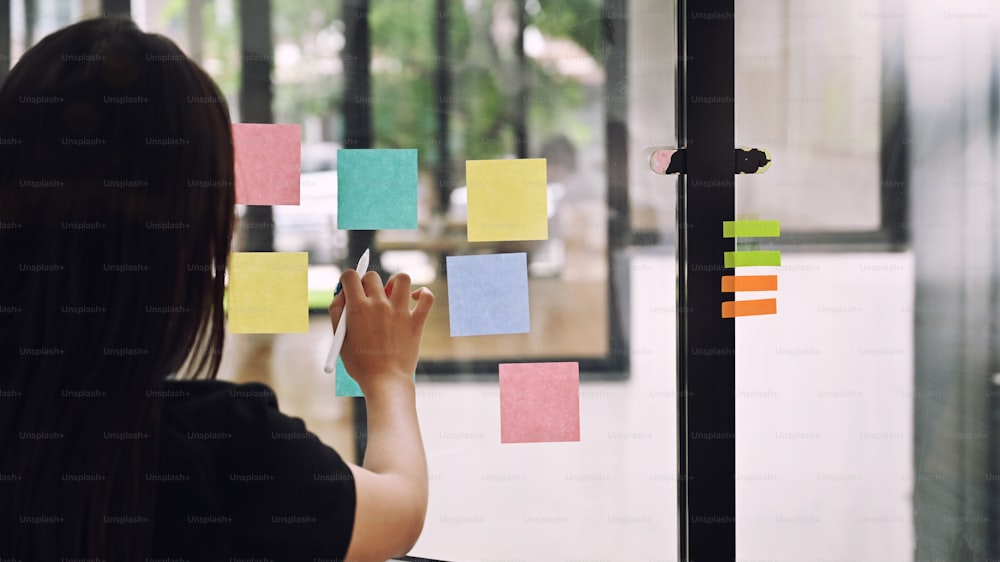 Behind shot Female meeting and use post it notes to share idea her on sticky note.