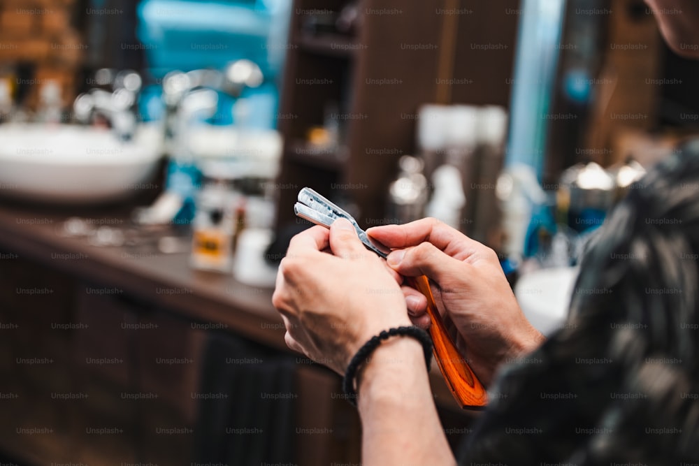 Domine el instrumento de afeitado desinfectante antes de su uso. Navaja de afeitar de cambio de spray para jóvenes, espacio libre. Ocupación, belleza, barbería, aseo, concepto de seguridad