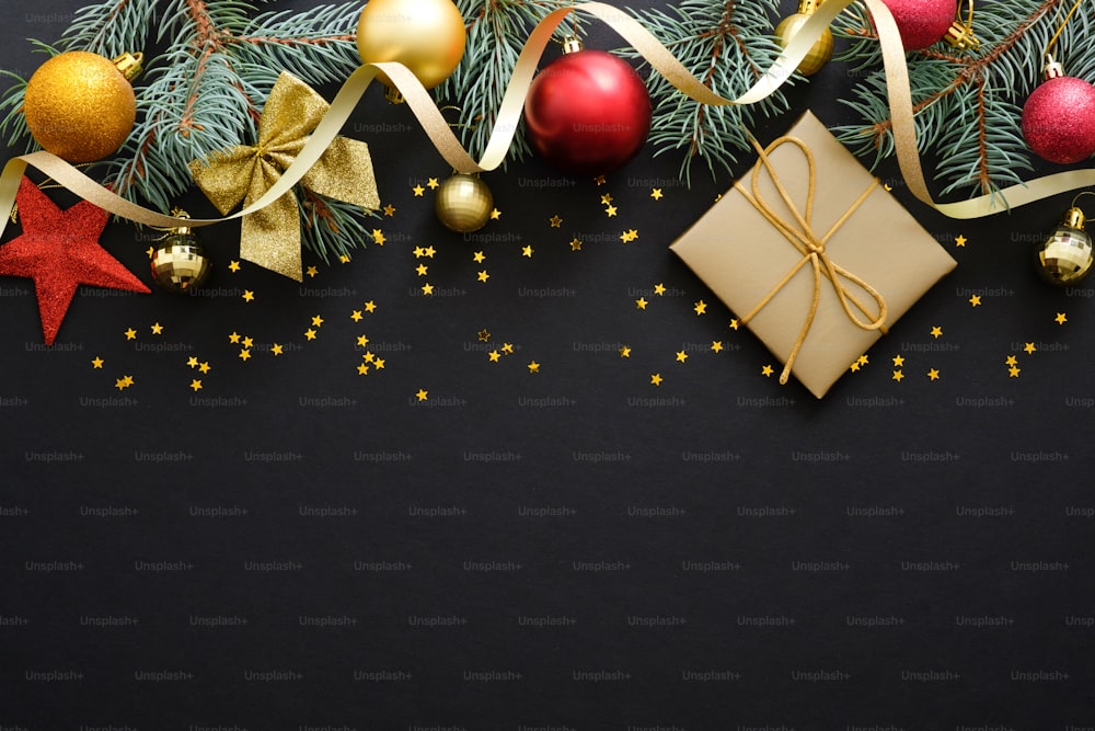 Fundo preto de Natal com galhos de abeto, decorações, enfeites vermelhos e dourados. caixa de presente, confete. Natal, férias de inverno, conceito de Ano Novo. Flat lay, vista superior. espaço de cópia. Banner de Natal