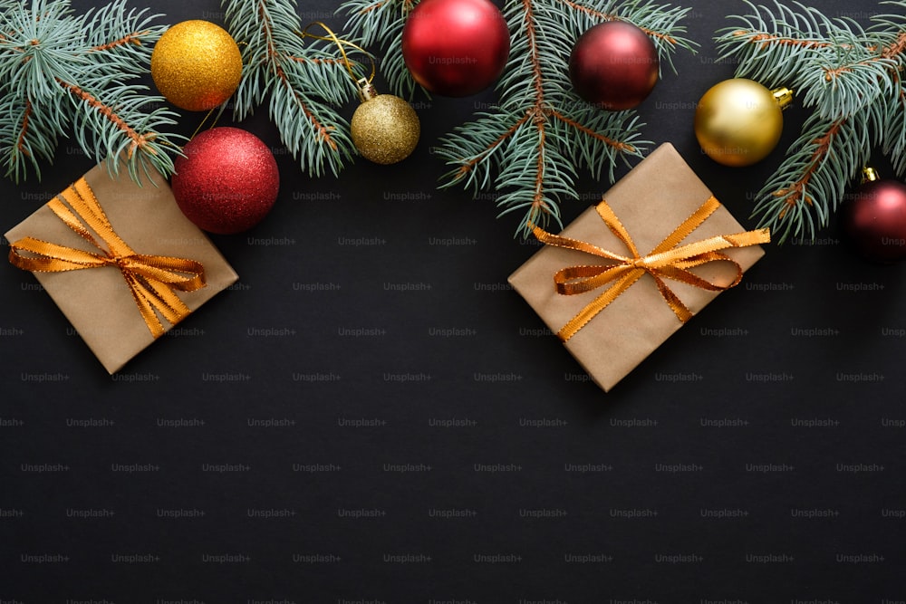 Weihnachtsrahmenbordüre mit goldenen und roten Dekorationen, Geschenkboxen, Kugeln auf dunkelschwarzem Hintergrund. Flaches Lay, Draufsicht, Kopierraum. Weihnachtsferien, Neujahrsgrußkarten-Mockup