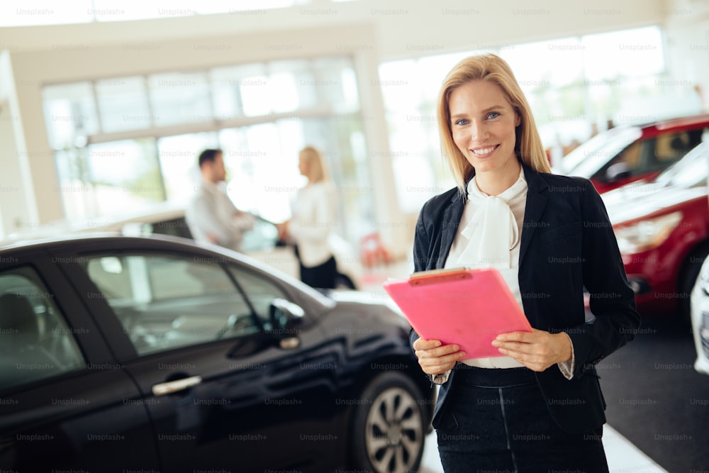 Professional gorgeous saleswoman at car dealership in formal wear. Super consultant or manager