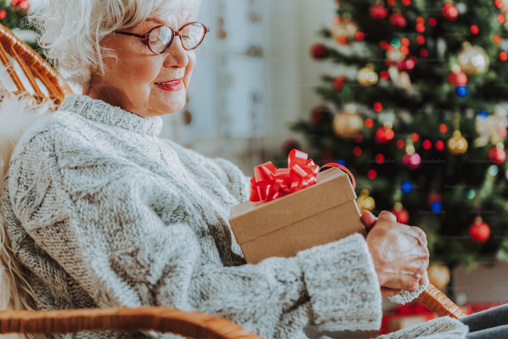 Happy mature female looking at Christmas present stock photo