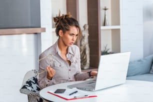 Young businesswoman misunderstanding her laptop at her desk in office