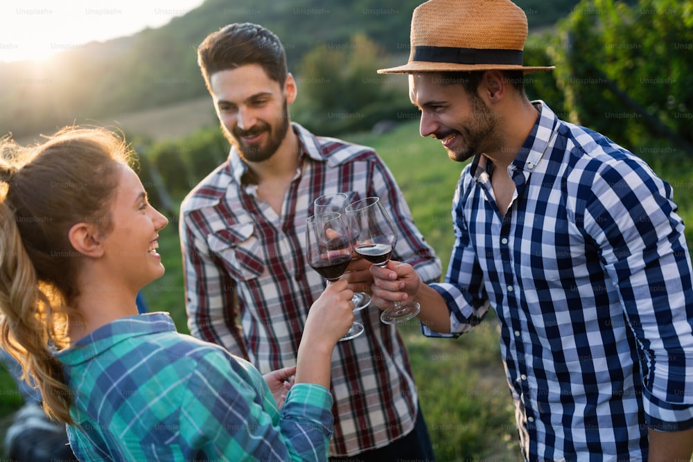 Picture of people tasting red wine in vineyard having fun time
