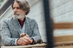 Handsome bearded gentleman looking away with serious expression stock photo