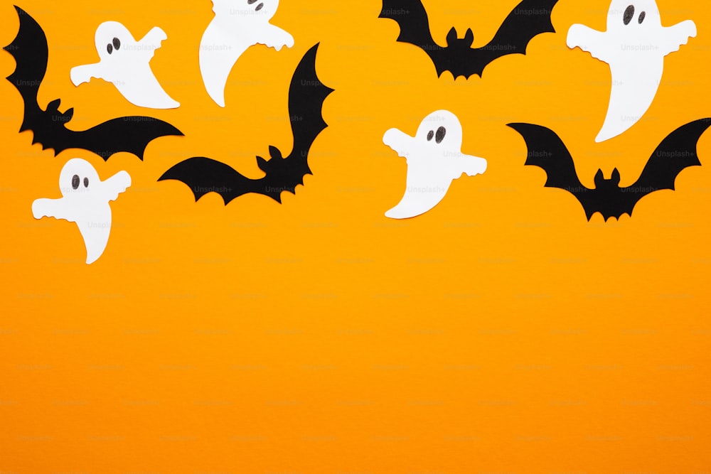 Feliz conceito de halloween. Quadro de decorações de Halloween, morcegos, fantasmas no fundo laranja. Maquete de cartão de felicitações da festa de Halloween com espaço de cópia. Flat lay, vista superior, sobrecarga.