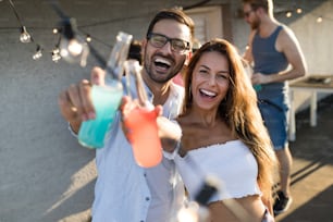 Cheerful young dancing couple having fun and enjoying party at summer