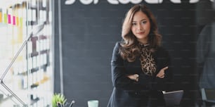 Empresária asiática bonita sorrindo e olhando para a câmera na sala de escritório moderna