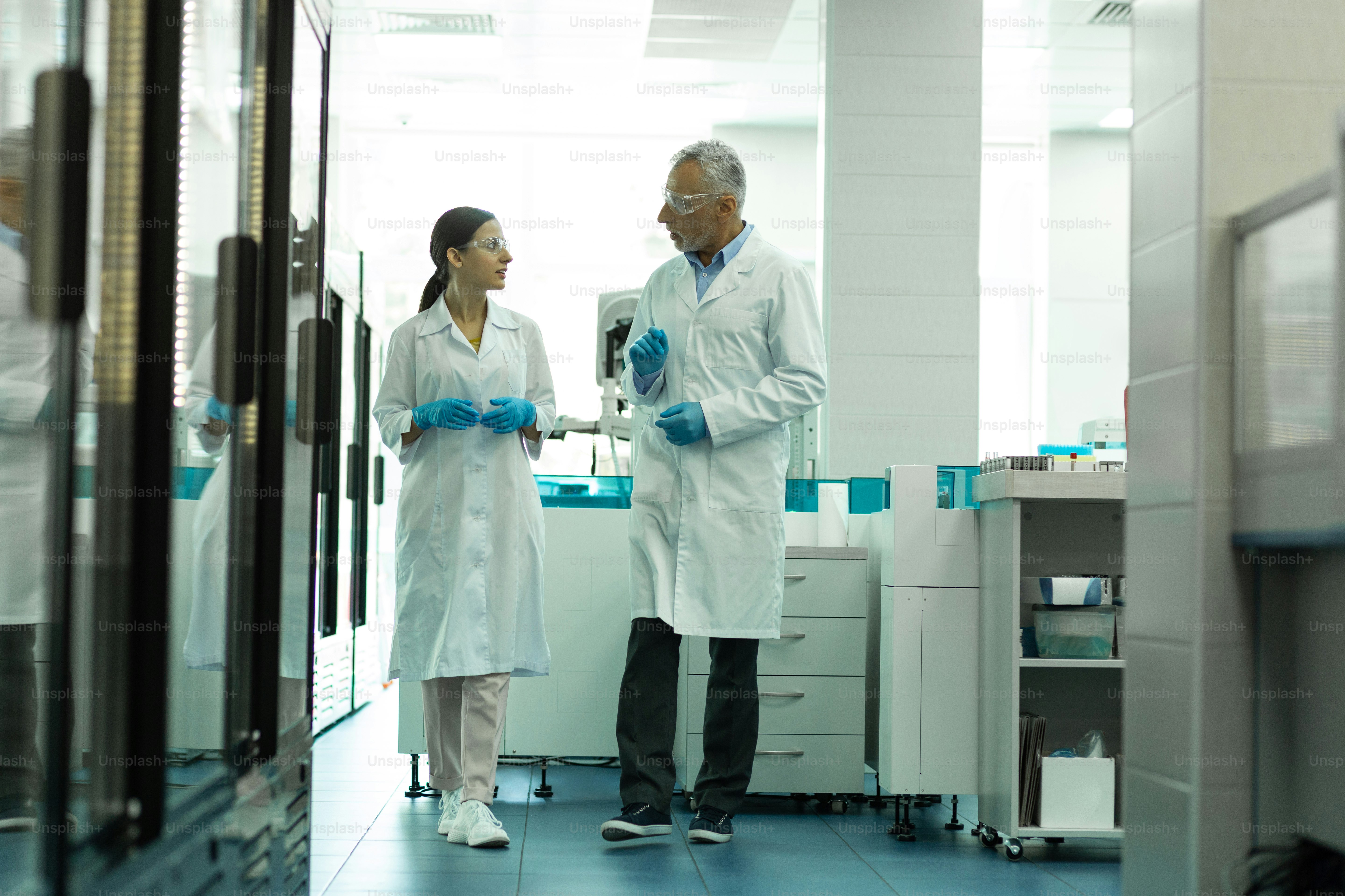 Freundliche Kollegen. Ernsthafter reifer Mediziner, der beim Gespräch mit seinem Studenten den Kopf dreht