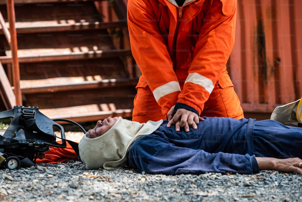 안전 구조 임무에 소방복을 입은 소방관의 중간 샷은 응급 응급 CPR로 불타는 건물 내에서 심장 마비 남자의 호흡을 멈추는 데 도움이됩니다. 안전, 구조 및 건강 관리 개념.
