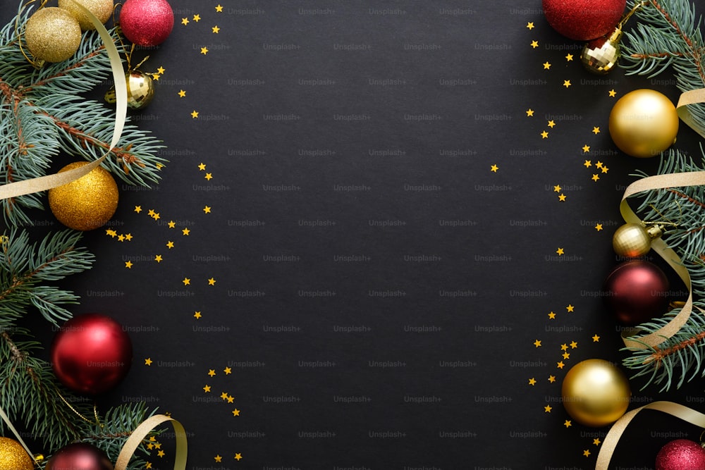 Black Christmas background with festive decorations, baubles, fir tree branches, confetti. Christmas holiday celebration, winter, New Year concept. Christmas banner mockup, greeting card template.
