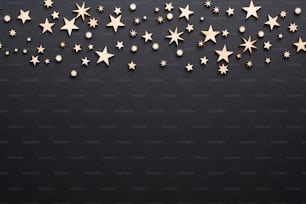 Christmas border frame with handmade wooden decorations. Christmas eve, dark night, black background with stars concept. Flat lay, top view, copy space