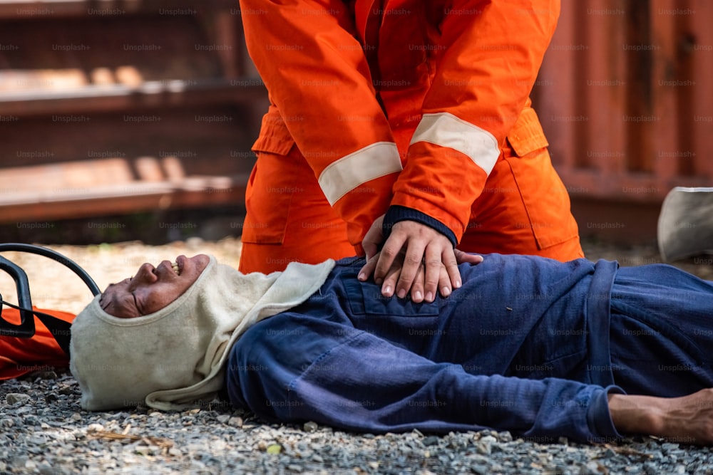 안전 구조 임무에 소방복을 입은 소방관의 중간 샷은 응급 응급 CPR로 불타는 건물 내에서 심장 마비 남자의 호흡을 멈추는 데 도움이됩니다. 안전, 구조 및 건강 관리 개념.