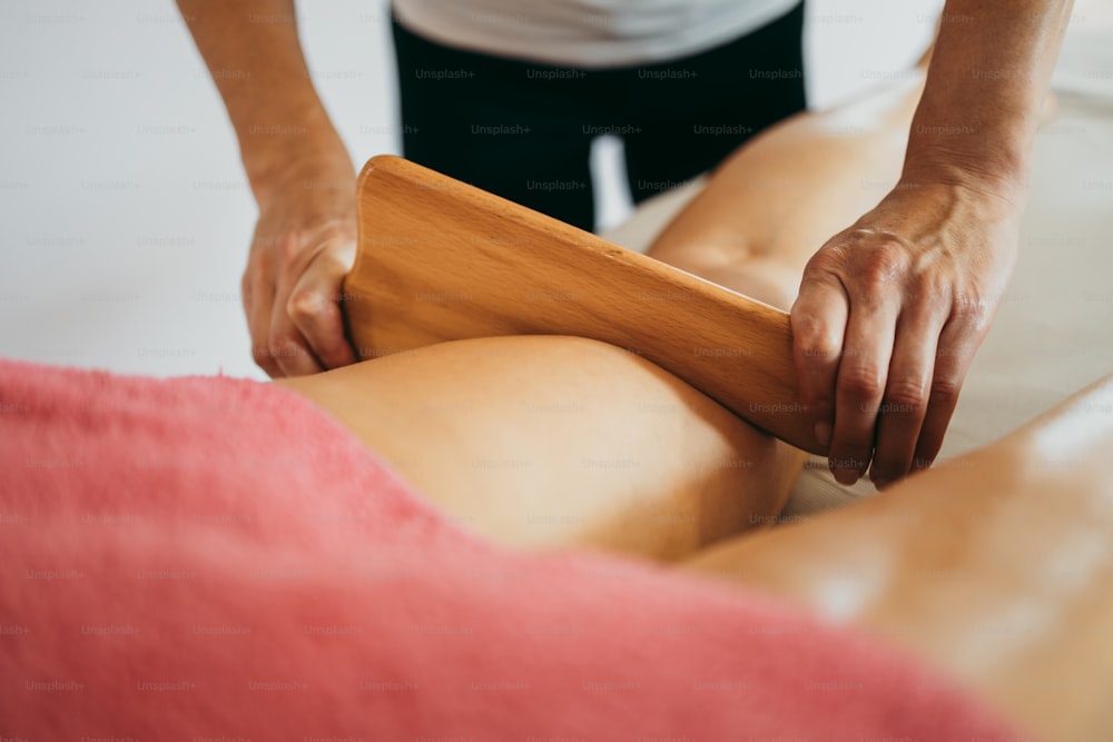 Femme d’âge moyen au traitement professionnel de massage de madérothérapie anti-cellulite. Plan rapproché.