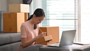 Éxito de la adolescente asiática haciendo negocios en casa para comprar en línea.