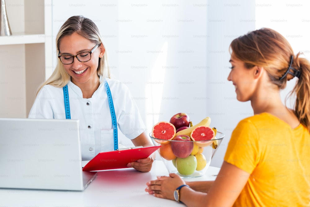 Doctor nutritionist, dietician and female patient on consultation in the office.