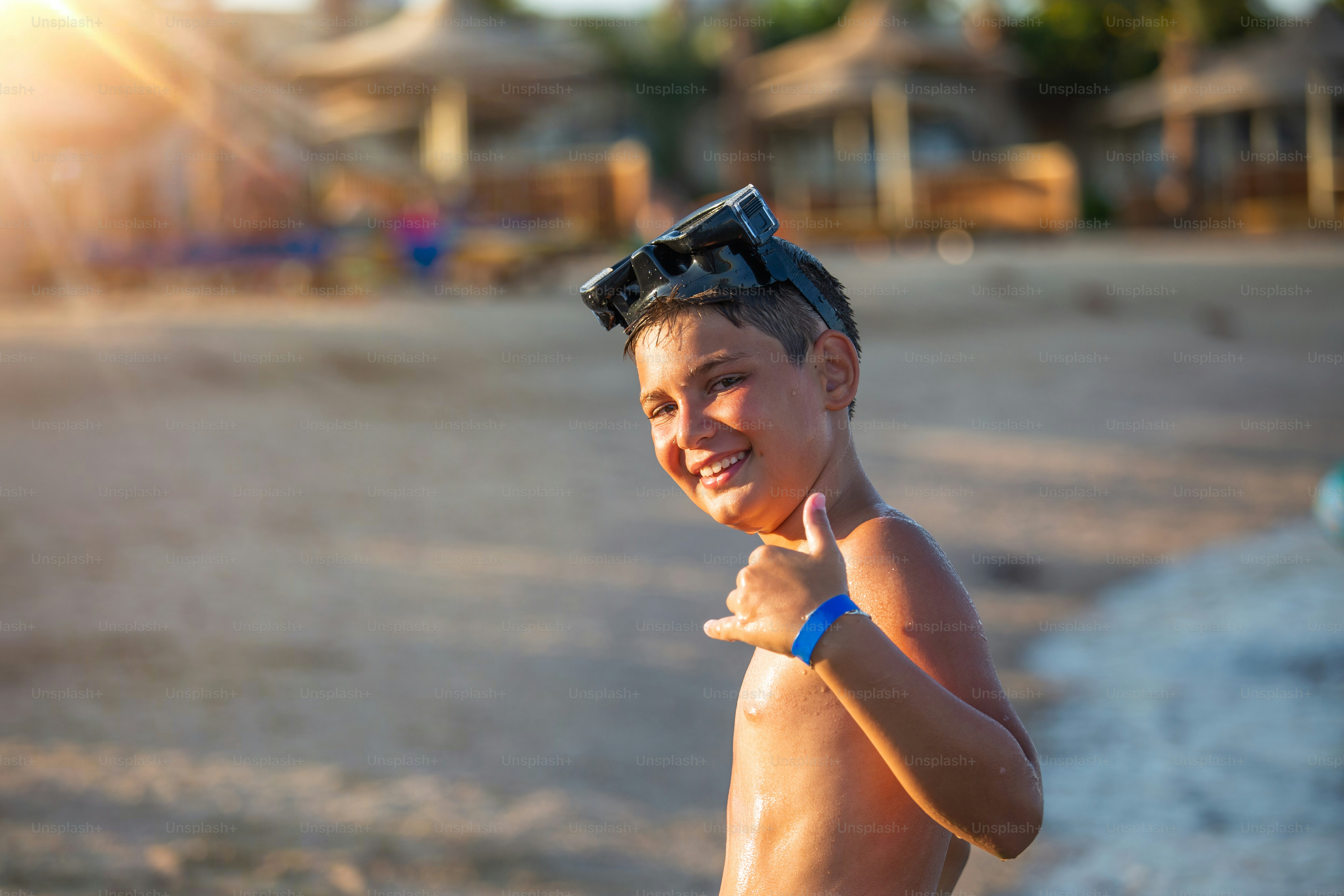 Summer fun young boy with a diving mask on running in the water