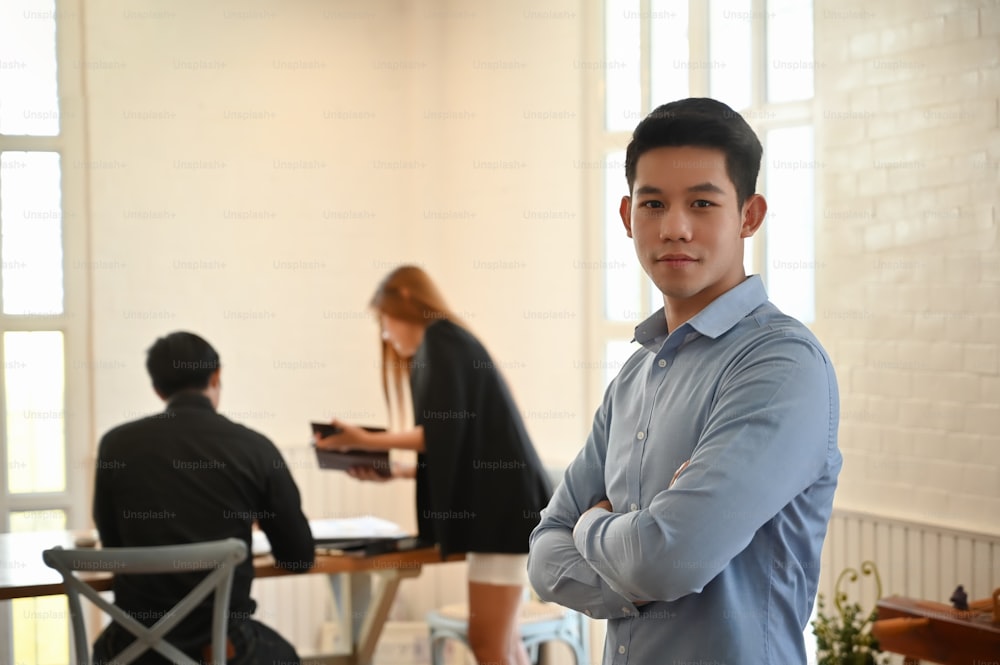 Confidently young businessman looking at the camera in meeting room.