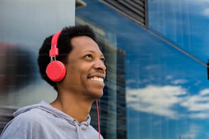 Young latin man listening music with headphones in the city. Enjoying concept.