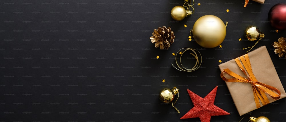 Bannière de héros de Noël. Fond de Noël noir avec décorations, boîte-cadeaux, boules, confettis, étoile. Affiche de Noël, modèle de carte de voeux, maquette de bannière d’en-tête. Mise à plat, vue de dessus, espace de copie