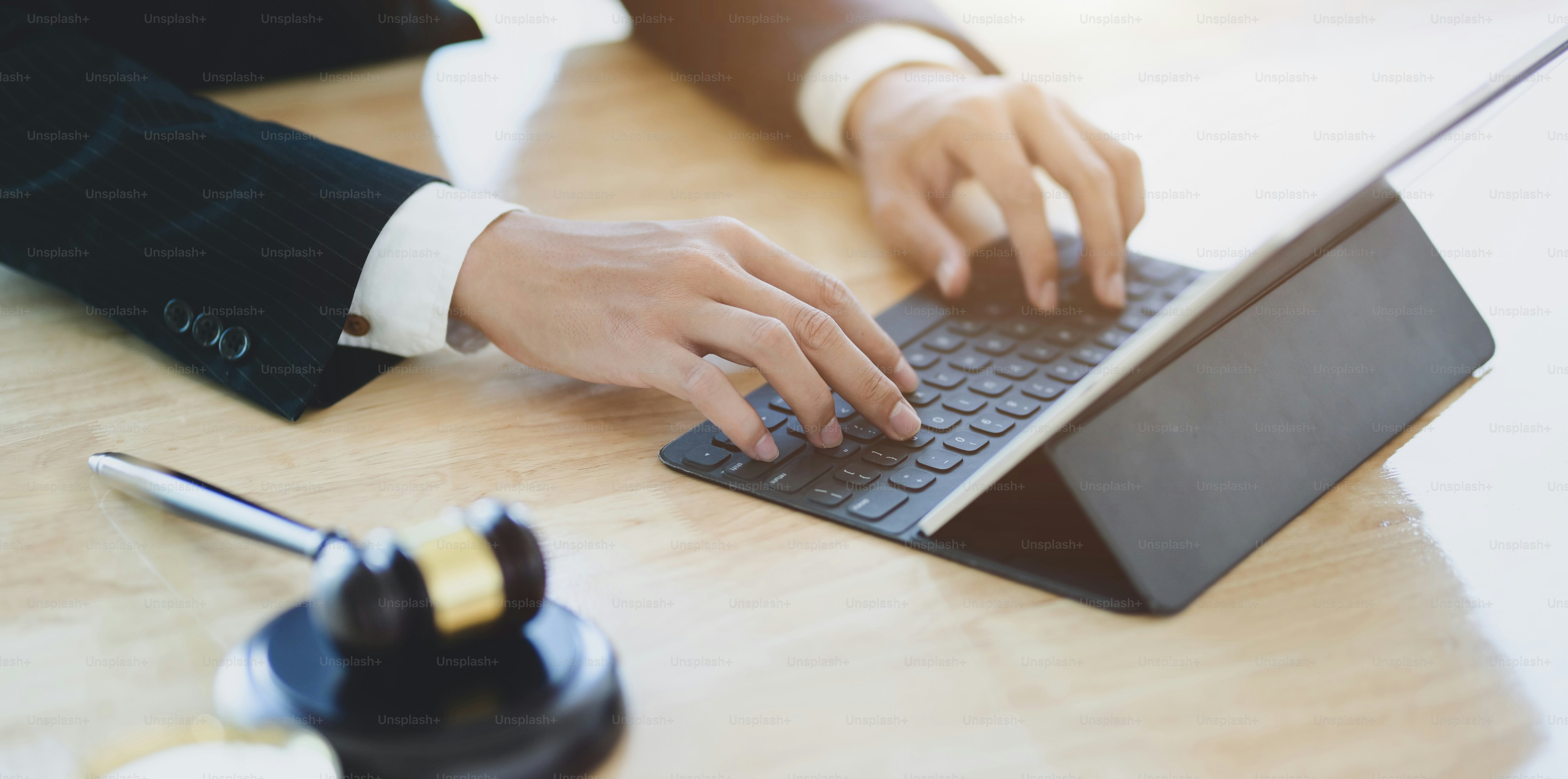 Male lawyer working on a laptop and providing legal document for his client