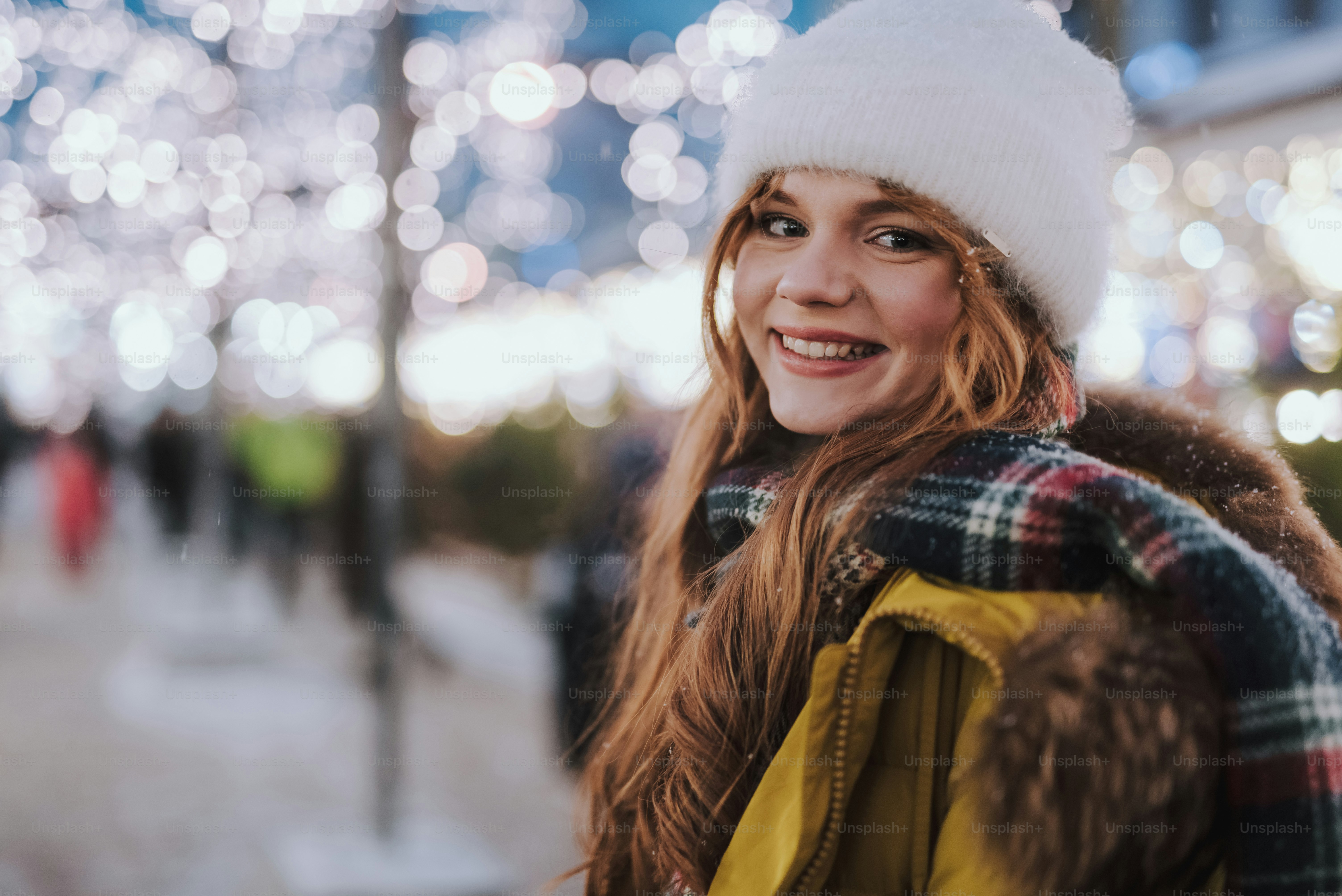 Junte-se a mim. Menina bonita mantendo o sorriso em seu rosto enquanto desfruta de sua caminhada na noite de inverno