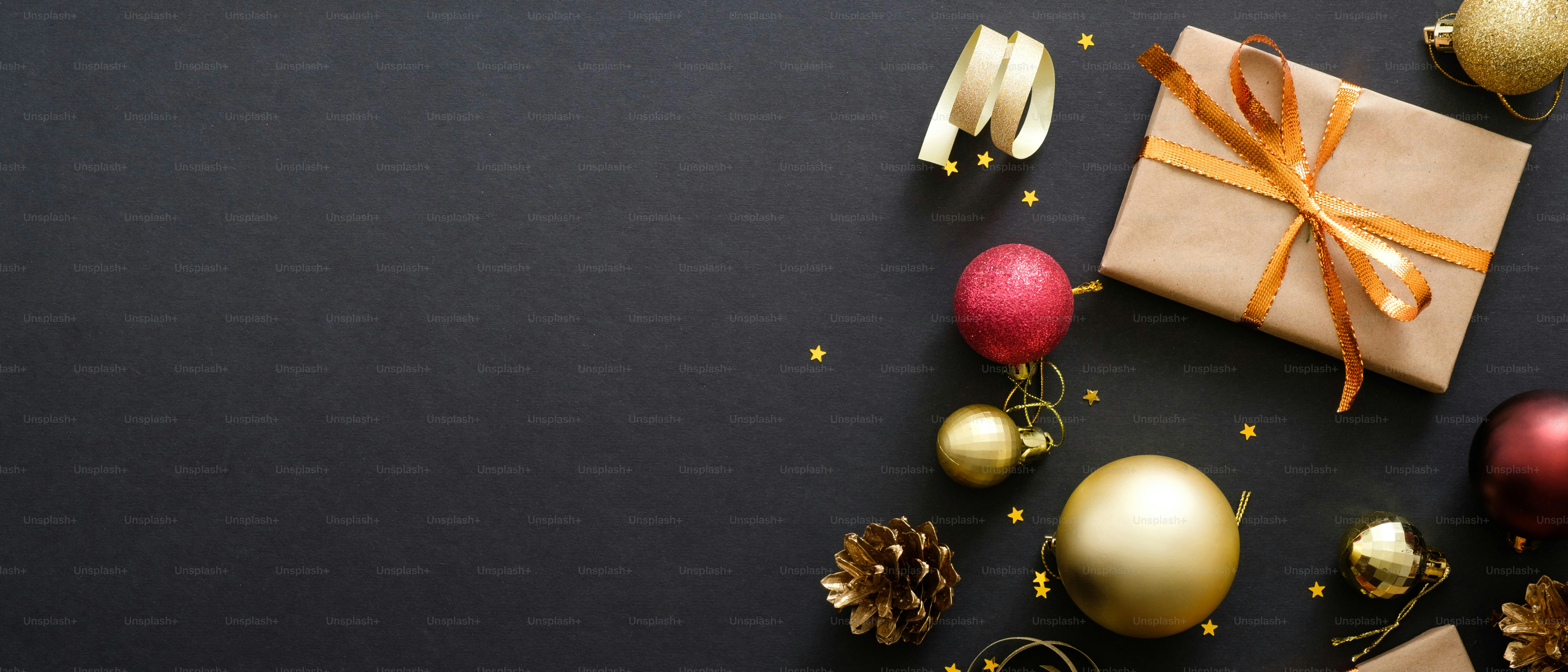 Christmas banner. Black Xmas background with decorations, gifts box, balls, confetti, star. Christmas poster, greeting card template, website header banner mockup. Flat lay, top view, copy space