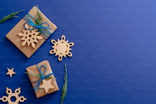 Weihnachtsliche Holzdekorationen und Geschenkboxen auf dunkelblauem Hintergrund mit Kopierraum. Weihnachtskarten-Mockup, festliche Social-Media-Bannervorlage. Winterurlaub, Weihnachten, Neujahrskonzept,