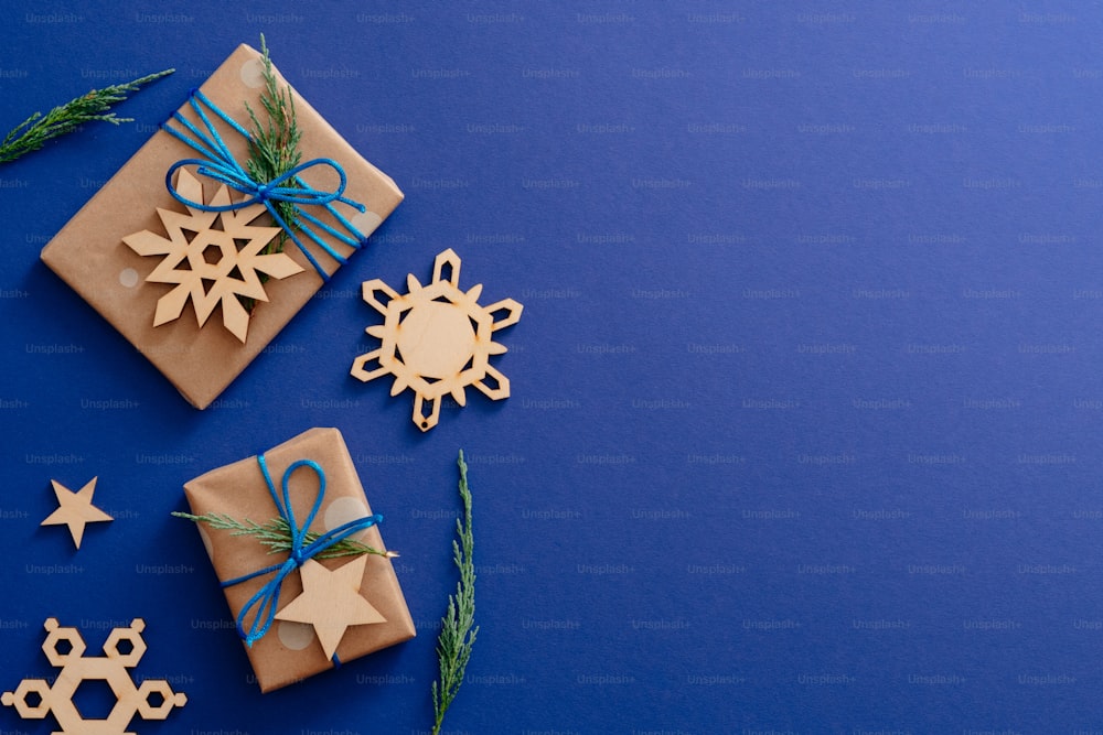 Decorações de madeira de Natal e caixas de presente no fundo azul escuro com espaço de cópia. Maquete de cartão de Natal, modelo de banner de mídia social festivo. Férias de inverno, Natal, conceito de Ano Novo,
