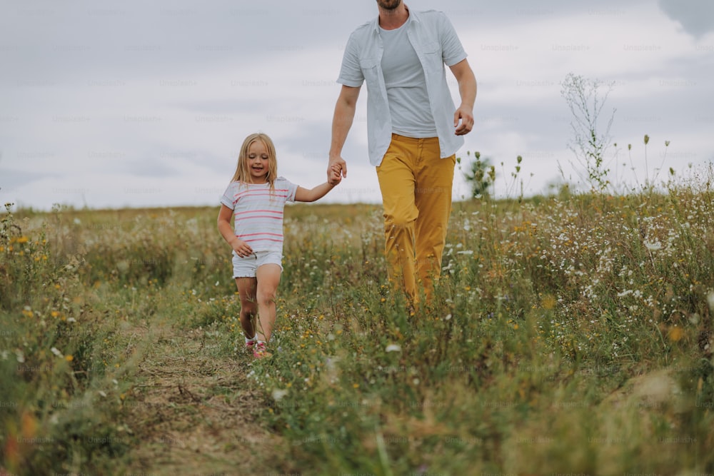 Pretty little girl holding father hand outdoors stock photo