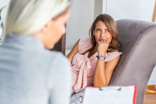Woman at therapy session. Attentive psychologist. Young woman at psychotherapy thinking about advice she received