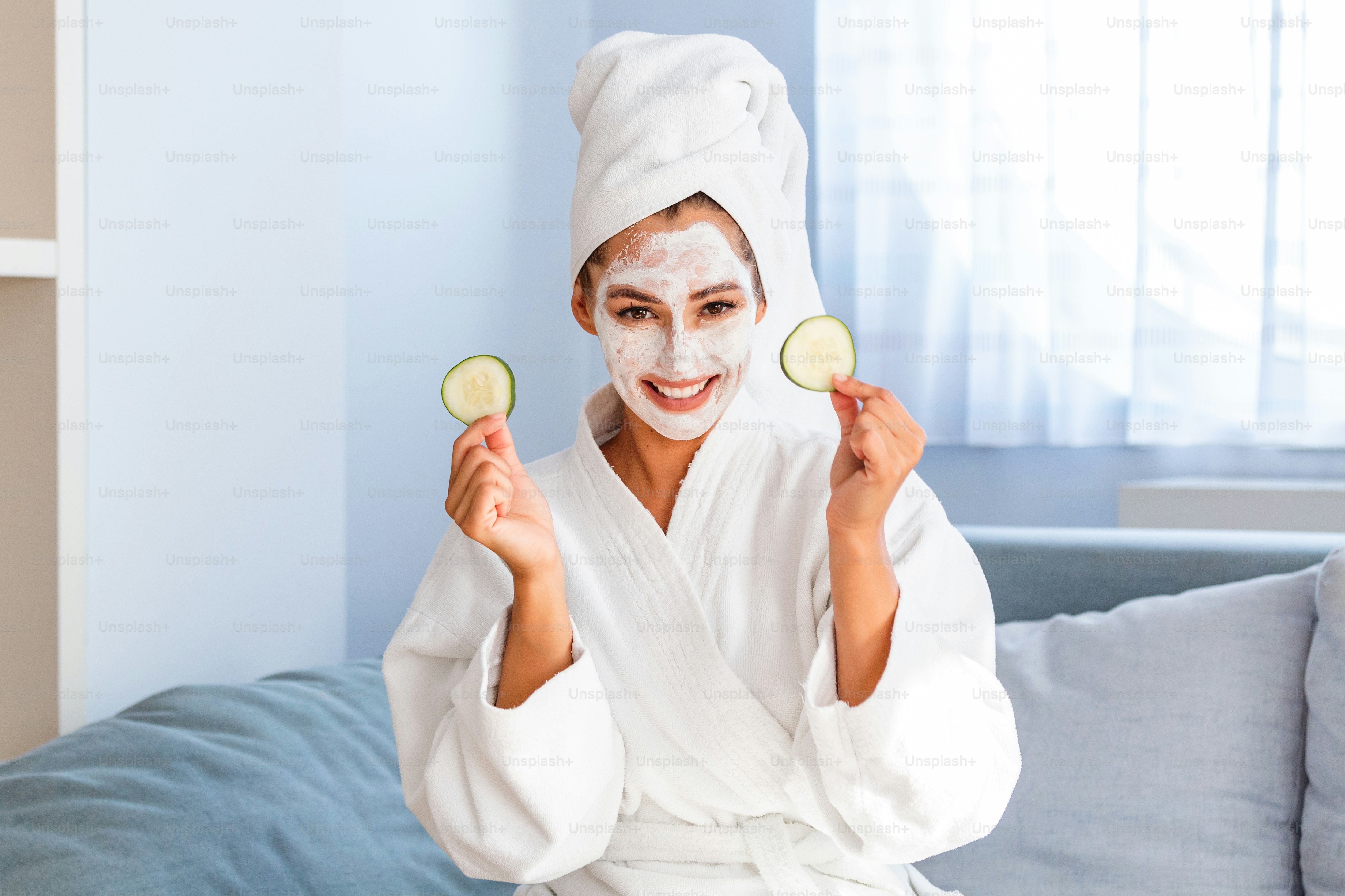 Natural homemade fresh cucumber facial eye pads facial masks. Woman holding cucumber pads and smile relax with natural homemade. Young woman with clay facial mask holding cucumber slices