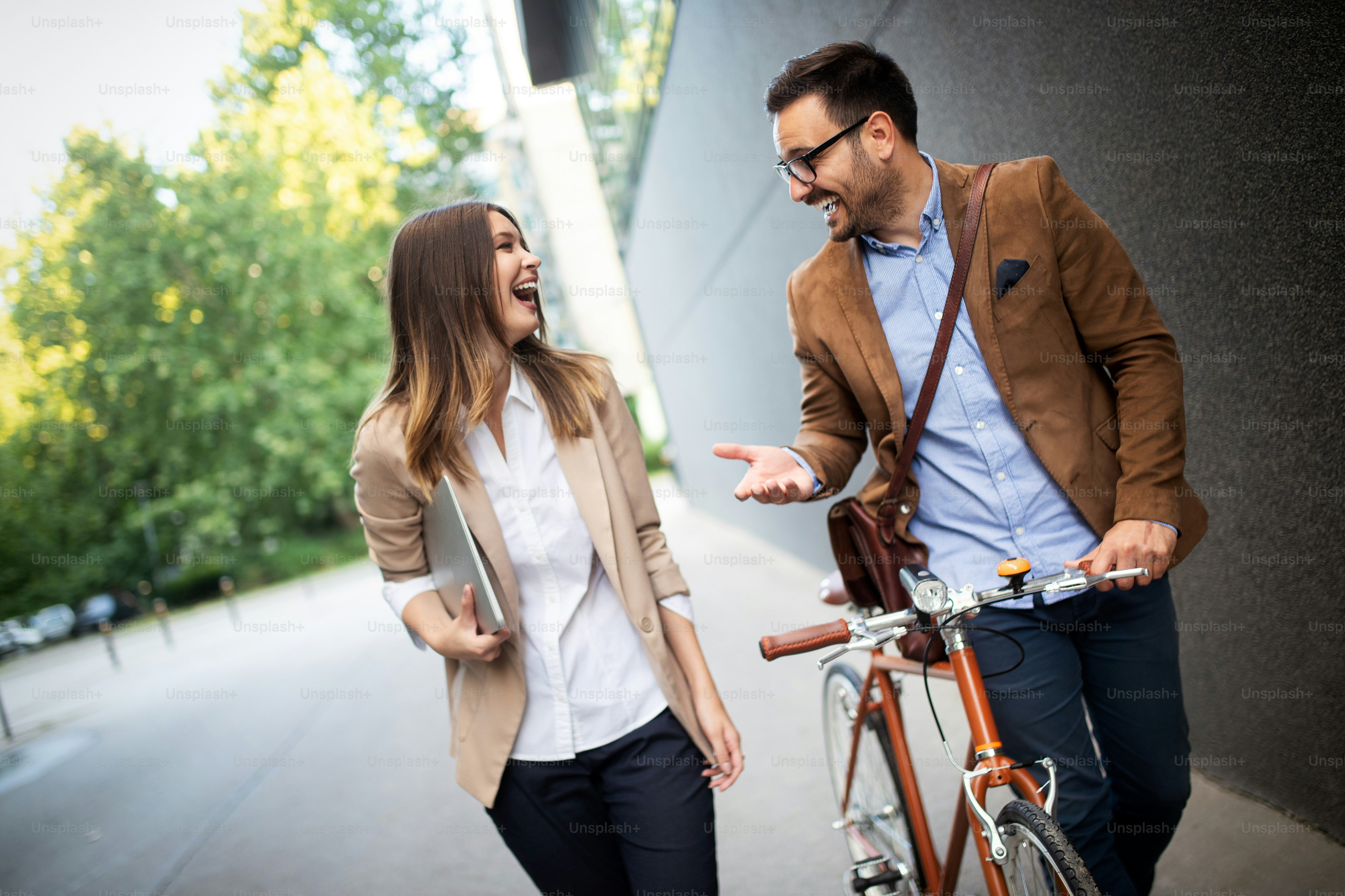 Happy office woman with business man couple enjoying break while talking flirting outdoor