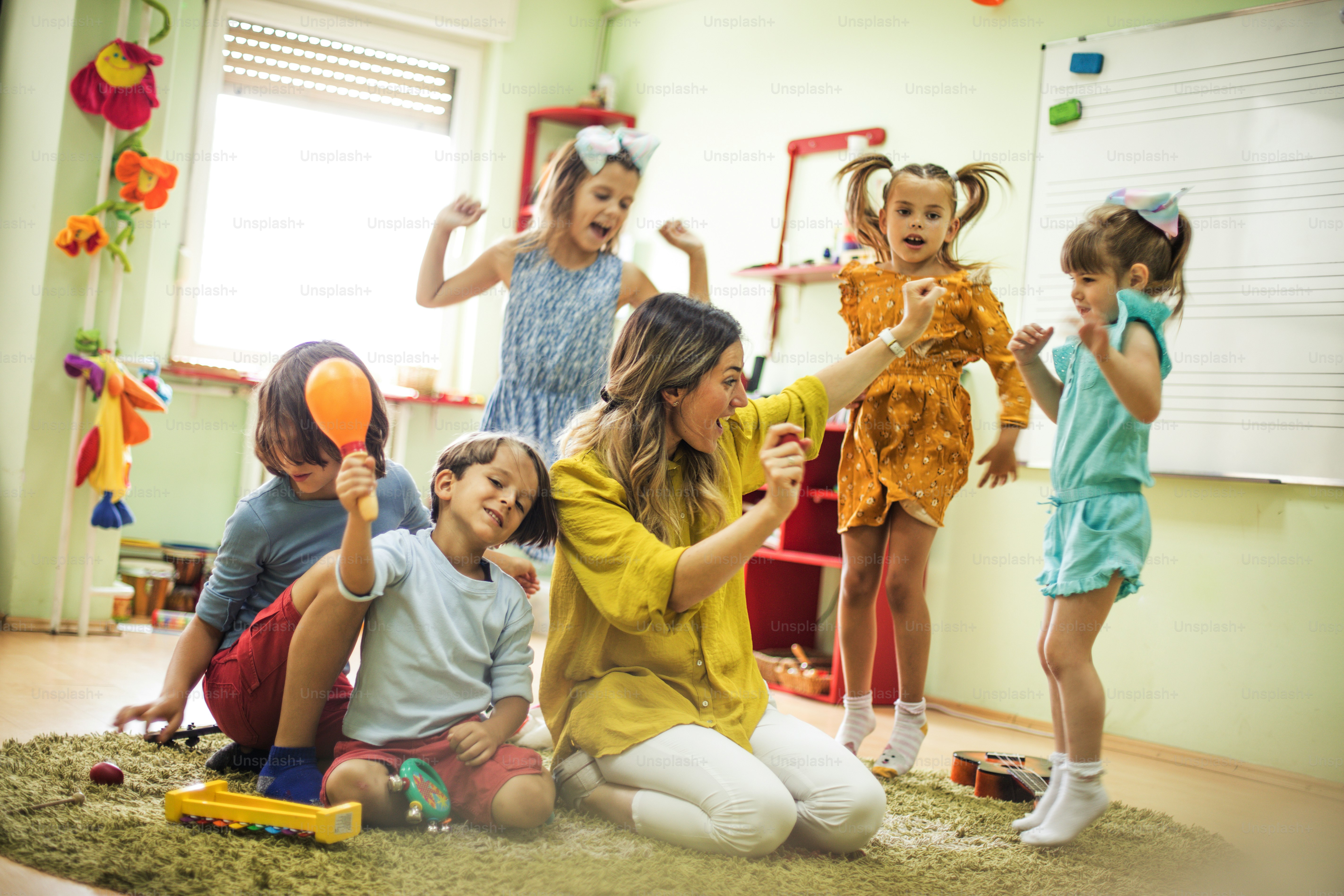 Dançar é divertido. Crianças com professor na pré-escola.